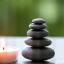 Candela accesa e sassi zen, simbolo di mindfulness